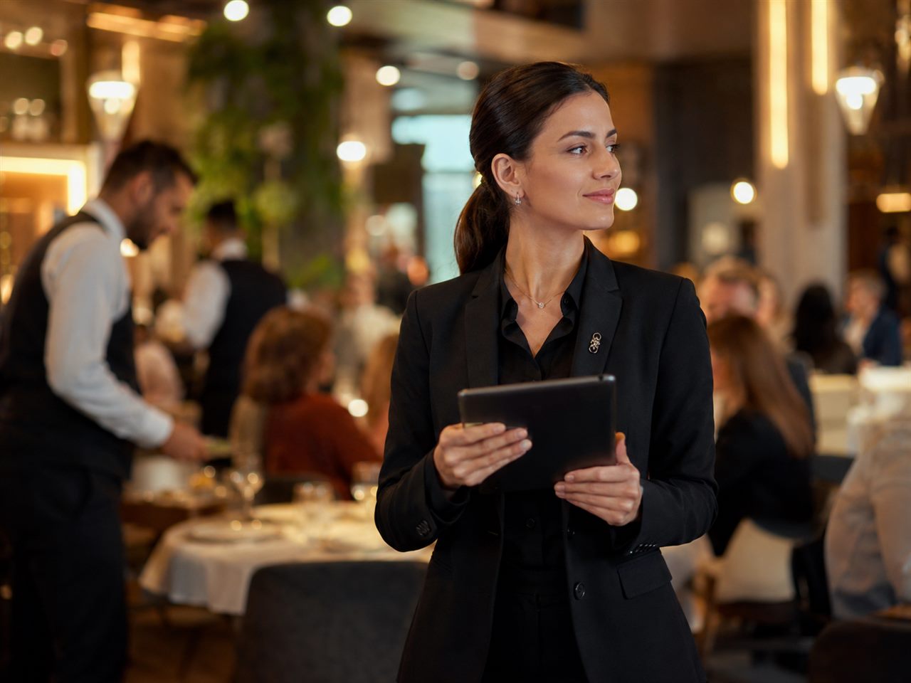 Jefe de sala consultando las reservas del día en una tablet durante el servicio